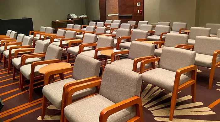 Upholstered wooden auditorium chairs set up for an event